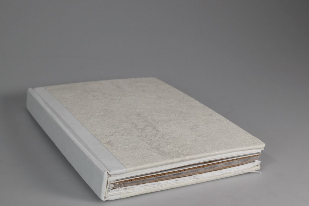 Bok med marmorerad omslag som påminner om tapeter.